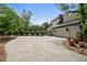Spacious driveway with ample parking space, leading to a modern home with lush landscaping at 9315 Prestwick Club Dr, Johns Creek, GA 30097