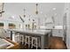 Large open kitchen with a stone island, white cabinets, and a view of the living area at 9315 Prestwick Club Dr, Johns Creek, GA 30097