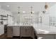 Spacious kitchen featuring a large island with a stone countertop, stainless steel appliances, and modern lighting at 9315 Prestwick Club Dr, Johns Creek, GA 30097