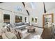 Spacious living room with vaulted ceilings, skylights, and a view of the outdoor pool area at 9315 Prestwick Club Dr, Johns Creek, GA 30097