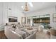 Bright living room boasts high ceilings, a decorative chandelier, and an oversized sectional couch at 9315 Prestwick Club Dr, Johns Creek, GA 30097