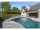 Resort-style pool area with a putting green, outdoor kitchen, and comfortable lounge chairs at 9315 Prestwick Club Dr, Johns Creek, GA 30097