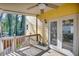 Covered back porch featuring wooden deck with fan, double doors, and wooded backyard at 1093 Third St, Stone Mountain, GA 30083
