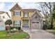 Charming two-story home with a stone accent garage, a manicured lawn, and a welcoming, light blue front door at 1093 Third St, Stone Mountain, GA 30083