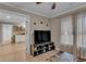 Cozy living room featuring hardwood floors, TV, and an open doorway to a kitchen with floating wood shelves at 1093 Third St, Stone Mountain, GA 30083