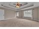 Spacious main bedroom with neutral carpet, ceiling fan, and natural light from large windows at 1093 Third St, Stone Mountain, GA 30083