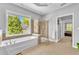 Bright bathroom boasts a soaking tub and glass enclosed shower with natural light at 3120 Abbey Sw Dr, Atlanta, GA 30331