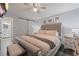Bright bedroom featuring a ceiling fan, tufted headboard, and ensuite bathroom entrance at 401 Berkeley Woods Dr, Duluth, GA 30096