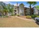 Exterior view of a multi-story condo building with manicured landscaping at 401 Berkeley Woods Dr, Duluth, GA 30096