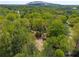 Aerial view of a charming home nestled among trees with Stone Mountain visible in the distance at 6141 Windsong Way, Smoke Rise, GA 30087