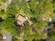 Aerial view of a home surrounded by lush greenery and mature trees, with a pool visible in the background at 6141 Windsong Way, Smoke Rise, GA 30087