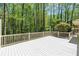 A white deck offers great space for relaxing with a peaceful view of the surrounding mature trees at 6141 Windsong Way, Smoke Rise, GA 30087