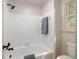 Bright bathroom featuring a tiled shower-tub combo, window, and modern fixtures at 6141 Windsong Way, Smoke Rise, GA 30087