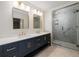 Bathroom featuring double vanity with gold hardware and a large, glass-enclosed shower with marble-style tile at 6141 Windsong Way, Smoke Rise, GA 30087