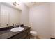 Well-lit half bathroom featuring a granite countertop and a classic oval sink at 6141 Windsong Way, Smoke Rise, GA 30087