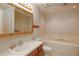 Bright bathroom with white vanity, large mirror, soaking tub, and tile surround at 6141 Windsong Way, Smoke Rise, GA 30087