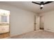 Bedroom showing a ceiling fan and en suite bathroom with carpeted flooring at 6141 Windsong Way, Smoke Rise, GA 30087