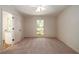 Bright carpeted bedroom with ceiling fan, neutral walls, and a window offering natural light at 6141 Windsong Way, Smoke Rise, GA 30087