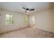 Carpeted bedroom with a ceiling fan, neutral paint, and a window providing natural light at 6141 Windsong Way, Smoke Rise, GA 30087