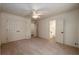 A carpeted bedroom with a ceiling fan and access to the ensuite bathroom at 6141 Windsong Way, Smoke Rise, GA 30087