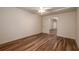 An airy room with wood laminate flooring, a ceiling fan, and a door leading to another room at 6141 Windsong Way, Smoke Rise, GA 30087