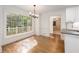 Bright dining room with large window and light fixture adjacent to the kitchen at 6141 Windsong Way, Smoke Rise, GA 30087