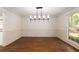 Dining room featuring hardwood floors, wainscoting, and modern lighting at 6141 Windsong Way, Smoke Rise, GA 30087