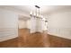 Open dining room featuring hardwood floors, wainscoting, and modern lighting at 6141 Windsong Way, Smoke Rise, GA 30087