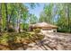 Traditional brick home with an attached garage and mature trees, showcasing a well-maintained landscape at 6141 Windsong Way, Smoke Rise, GA 30087