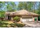 Brick home featuring an attached garage, well-manicured lawn, and traditional architectural details at 6141 Windsong Way, Smoke Rise, GA 30087
