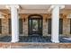 Elegant front entryway with a stylish door, decorative columns, and a brick facade at 6141 Windsong Way, Smoke Rise, GA 30087