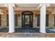 Elegant front entrance with stately columns, brickwork, and a stylish front door at 6141 Windsong Way, Smoke Rise, GA 30087