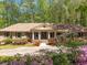 Charming brick home with a columned porch, beautifully landscaped front yard, and blooming flowers at 6141 Windsong Way, Smoke Rise, GA 30087