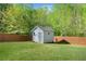 The backyard features a small, charming shed and is surrounded by a wooden privacy fence at 327 Morning Frost, Canton, GA 30114