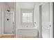 Bright bathroom featuring a tub with decorative window and separate shower stall at 327 Morning Frost, Canton, GA 30114