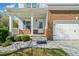 Charming front entrance with brick accents and white columns, offering a warm welcome at 327 Morning Frost, Canton, GA 30114