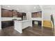 Modern kitchen featuring dark wood cabinets, stainless steel appliances, and a large island with granite countertops at 327 Morning Frost, Canton, GA 30114