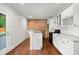 Kitchen with white cabinetry, marble countertops and a brick accent wall at 327 Morning Frost, Canton, GA 30114