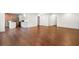 Open-concept living room with hardwood floors, white walls, and a brick accent wall at 327 Morning Frost, Canton, GA 30114