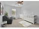 Stylized room with modern ceiling fan, a crib, a chair and a rug with an elephant at 4915 Bergen Ct, Cumming, GA 30040