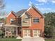 Charming two-story brick home with a well-manicured lawn and inviting front porch, complemented by an attached two-car garage at 4915 Bergen Ct, Cumming, GA 30040