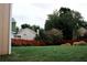 Well-kept backyard with mature landscaping, a wooden fence, and a spacious green lawn at 4406 Dickens Nw Ct, Kennesaw, GA 30144