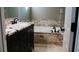 Bathroom showcasing a soaking tub with tiled surround and a vanity with granite countertop at 4406 Dickens Nw Ct, Kennesaw, GA 30144