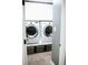 Bright laundry room with front loading washer and dryer with storage baskets below at 4406 Dickens Nw Ct, Kennesaw, GA 30144