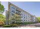 Exterior view of building showcasing balconies, architectural details, landscaping, and a clear blue sky at 3203 Lenox Ne Rd # 32, Atlanta, GA 30324