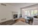 Bright living room showcasing a fireplace, French doors leading to a balcony, and a stylish cowhide rug at 3203 Lenox Ne Rd # 32, Atlanta, GA 30324