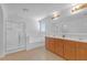 Modern bathroom features a glass-enclosed shower, soaking tub, and double vanity with wood cabinets at 3447 Dogwood Pass, Lithonia, GA 30038