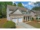 Side view of a brick front home featuring a two-car garage and lush landscaping at 3447 Dogwood Pass, Lithonia, GA 30038