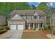 Charming two-story home features a two-car garage, brick facade, and beautifully landscaped front yard at 3447 Dogwood Pass, Lithonia, GA 30038