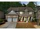 Charming two-story home features a two-car garage, brick facade, and beautifully landscaped front yard at 3447 Dogwood Pass, Lithonia, GA 30038
